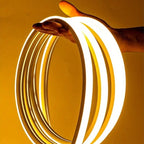 Neon light strip held by a hand against a yellow background