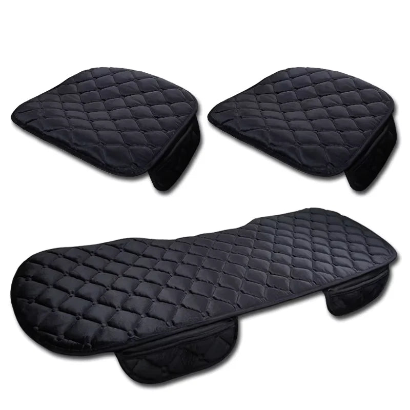 Three black quilted seat covers on a white background